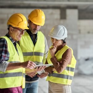 Three caucasian engineers discussing over digital tablet on the construction site
