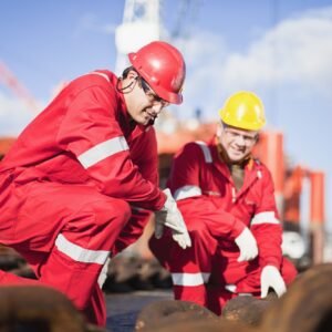 Workers on oil rig examining chains